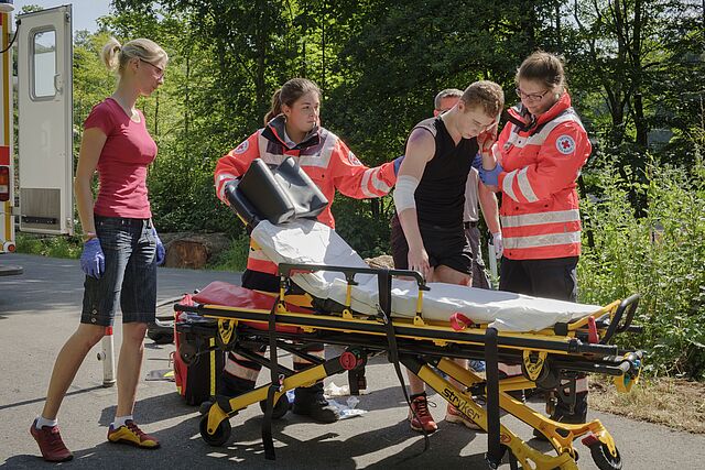 Helfer beim versorgen eines Verletzten nach einem Fahrradunfall